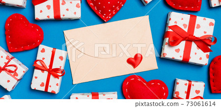 Top view of colorful valentine background made of craft envelope, gift boxes and red textile hearts. Valentine's Day concept Top view of colorful valentine background made of craft envelope, gift boxes and red textile hearts. Valentine's Day concept 73061614