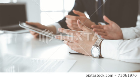 Unknown business people using tablet computer in modern office. Businessman or male entrepreneur is working with his colleague at the desk Unknown business people using tablet computer in modern office. Businessman or male entrepreneur is working with his colleague at the desk 73061970
