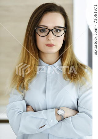 Business woman headshot at workplace in modern office. Unknown businesswoman standing straight with tablet computer. Young accountant or secretary looks good Business woman headshot at workplace in modern office. Unknown businesswoman standing straight with tablet computer. Young accountant or secretary looks good 73061971