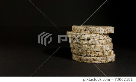 Grain crispbreads crispy rice and diet bread. Stack of puffed whole grain crispbread. Rice cake puffed rice on black background Grain crispbreads crispy rice and diet bread. Stack of puffed whole grain crispbread. Rice cake puffed rice on black background 73062191