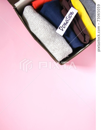 Clothes sorting in wardrobe for donation with paper note. 73065059