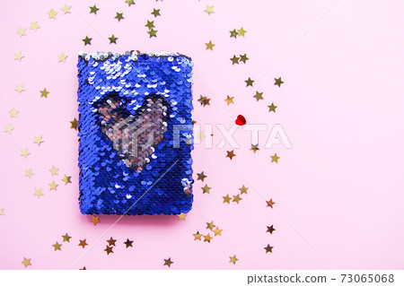 Bright composition of fashion stationery. Glitter sequins notepad and decorative tinsel. Different objects on soft pastel background. Flat lay, top view 73065068