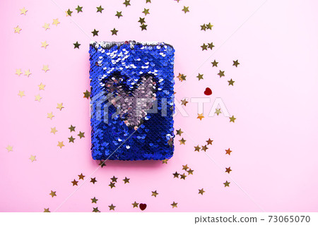 Bright composition of fashion stationery. Glitter sequins notepad and decorative tinsel. Different objects on soft pastel background. Flat lay, top view 73065070