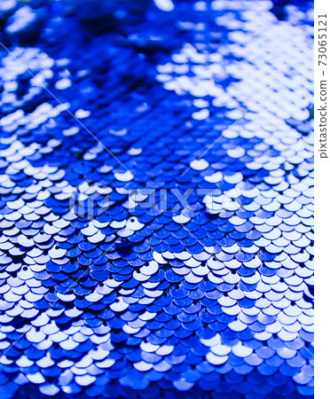 Bright shiny texture of colorful sequins in blue and purple colors. Fashion fabric background. 73065121