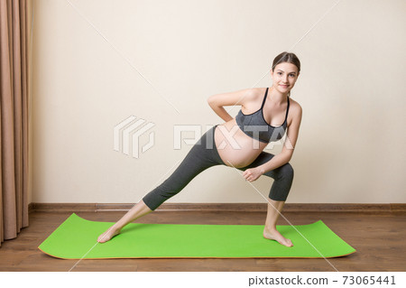 Portrait of young pregnant yoga model working at the home. Pregnancy Yoga and Fitness concept at coronavirus time 73065441