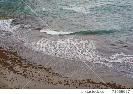 Photography of the Atlantic Ocean surf in the Bay of Biscay. Waves running onto the sandy shore in summer day. Natural fresh background for poster, banner, postcard, greeting card, touristic guide Photography of the Atlantic Ocean surf in the Bay of Biscay. Waves running onto the sandy shore in summer day. Natural fresh background for poster, banner, postcard, greeting card, touristic guide 73066657