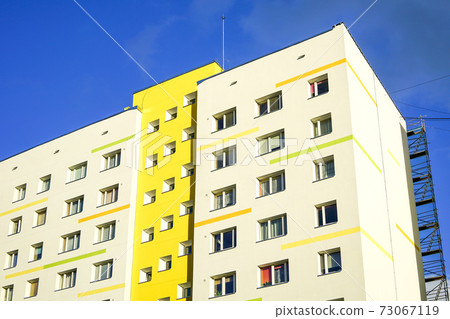 a fragment of the facade of an apartment building that has just been renovated 73067119