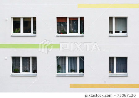 a fragment of the facade of an apartment building that has just been renovated 73067120