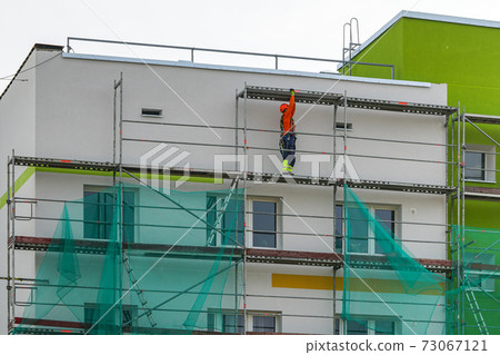 demolition of scaffolding after thermal insulation and painting of the facade of an apartment house demolition of scaffolding after thermal insulation and painting of the facade of an apartment house 73067121