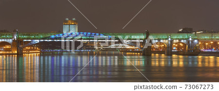 Moscow bright illuminated cityscape. Andreevsky (Pushkinsky) pedestrian bridge, Moskva river, Gorky park, Academy of sciences. Neskuchny Garden. dark winter night sky during coronavirus pandemic time 73067273