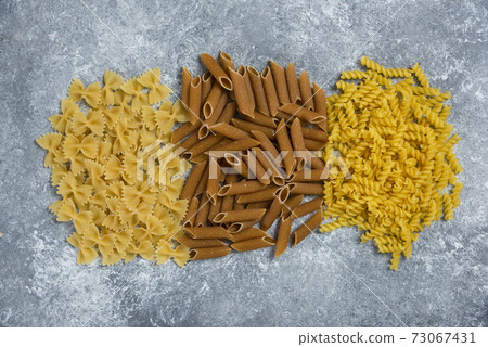 Different types of pasta on a gray background Different types of pasta on a gray background 73067431
