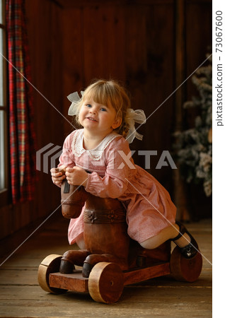Little cute blond girl standing at headboard of iron bed 73067600