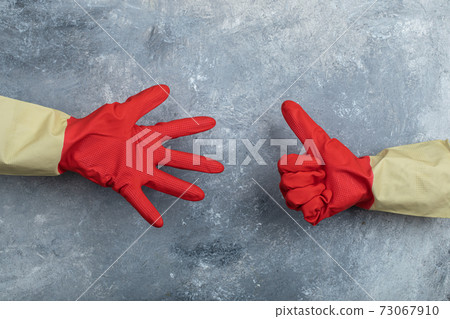 Hands in red protective gloves giving thumbs up Hands in red protective gloves giving thumbs up 73067910