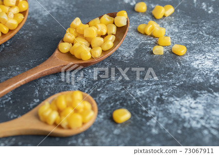Delicious sweet corn on wooden spoons Delicious sweet corn on wooden spoons 73067911