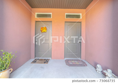 Front doors and porch of pink townhouse duplex Front doors and porch of pink townhouse duplex 73068735