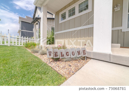 Welcome sign in front garden of traditional home 73068781