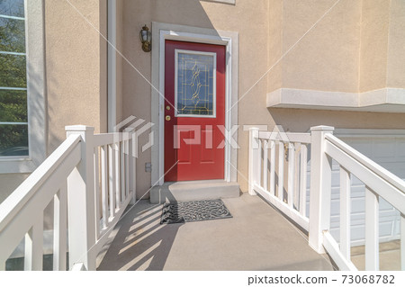Red front door and steps of traditional home 73068782