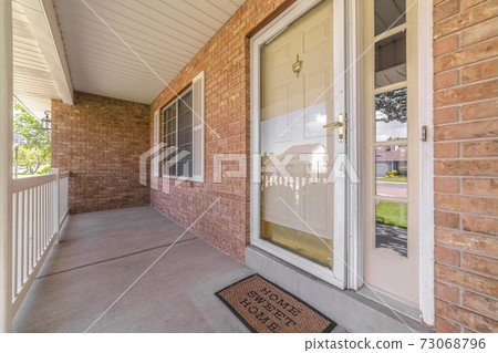 Front door of suburban brick home with welcome mat Front door of suburban brick home with welcome mat 73068796