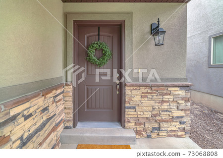 Front door of suburban home with green wreath Front door of suburban home with green wreath 73068808