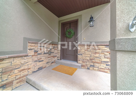 Entrance door to a house with feature stone wall Entrance door to a house with feature stone wall 73068809