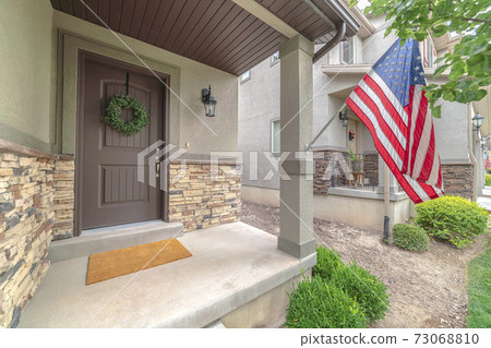 Front door of suburban home with American flag 73068810