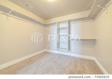 Interior of walk in closet with bare shelving Interior of walk in closet with bare shelving 73068820