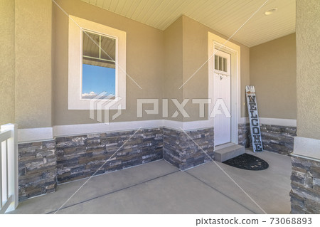 Front veranda of modern home with welcome sign 73068893