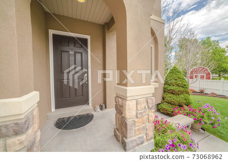 Porch and front door of modern house with garden 73068962