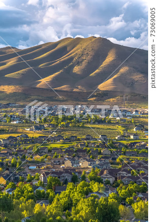 Town nestling in a valley with green trees Town nestling in a valley with green trees 73069005