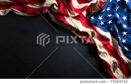 Martin Luther King Day anniversary concept. American flag against black wooden background 73069742