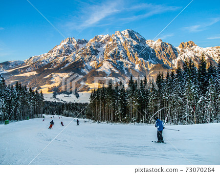 Downhill skiers in winter Alps 73070284