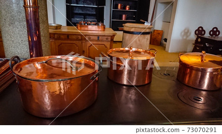 Kitchen of the old castle. Copper pans, baking molds and other kitchen utensils 73070291