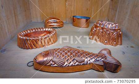 Kitchen of the old castle. Copper pans, baking molds and other kitchen utensils Kitchen of the old castle. Copper pans, baking molds and other kitchen utensils 73070295