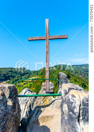 Wooden cross on the top rock Wooden cross on the top rock 73070481