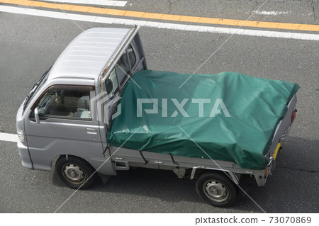 A light truck that covers the green sheet on the loading platform 73070869