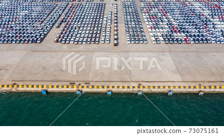 Aerial view row of new cars parked at commercial port for import and export business logistic to dealership for sale, Automobile and automotive car parking lot for commercial global business industry. 73075161
