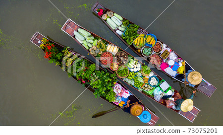 Aerial view famous floating market in Thailand, Damnoen Saduak floating market, Farmer go to sell organic products, fruits, vegetables and Thai cuisine, Tourists visiting by boat, Ratchaburi, Thailand Aerial view famous floating market in Thailand, Damnoen Saduak floating market, Farmer go to sell organic products, fruits, vegetables and Thai cuisine, Tourists visiting by boat, Ratchaburi, Thailand 73075201