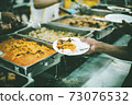 Homeless and needy people receive help, receive food from volunteers 73076532