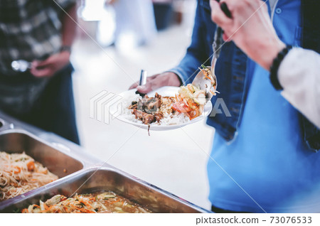 Homeless and needy people receive help, receive food from volunteers Homeless and needy people receive help, receive food from volunteers 73076533
