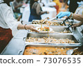 Homeless and needy people receive help, receive food from volunteers 73076535