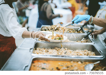 Homeless and needy people receive help, receive food from volunteers Homeless and needy people receive help, receive food from volunteers 73076535