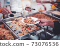 Homeless and needy people receive help, receive food from volunteers 73076536