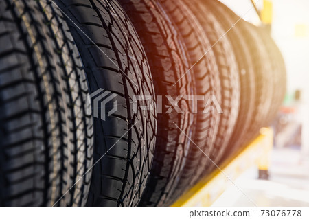 Car tires on shelf in garage shop for sale various type of tyre. Car tires on shelf in garage shop for sale various type of tyre. 73076778