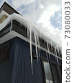 Icicles hanging from the eaves of the house 73080033