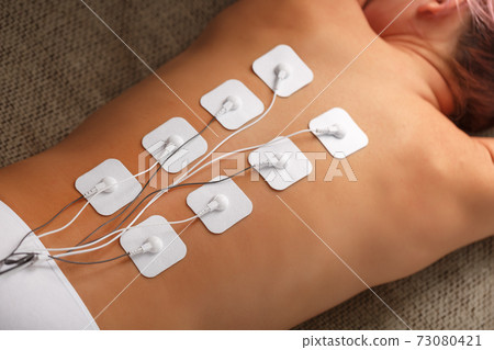 Myostimulation procedure on the back in a beauty salon. Myostimulation procedure on the back in a beauty salon. 73080421