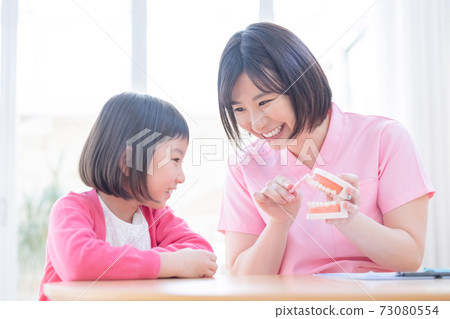 Dentist: A girl and a dentist who receive tooth brushing instruction Dentist: A girl and a dentist who receive tooth brushing instruction 73080554
