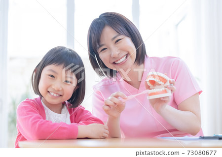 Dentist: A girl and a dentist who receive tooth brushing instruction Dentist: A girl and a dentist who receive tooth brushing instruction 73080677