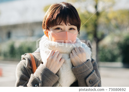 Winter woman wearing a coat, scarf and mask 73080692