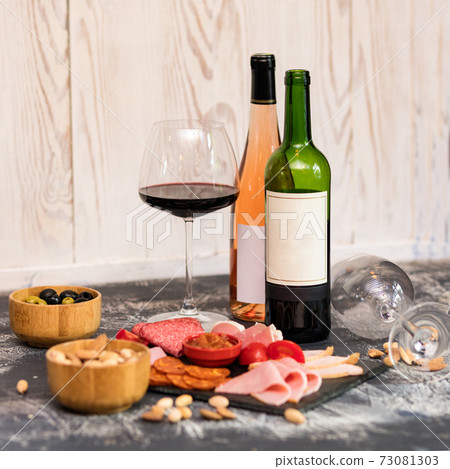 Wine bottle, glass with tasty sausage, tomato and sauce Wine bottle, glass with tasty sausage, tomato and sauce 73081303