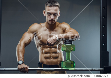 Bodybuilder drinking water after fitness workout 73082074